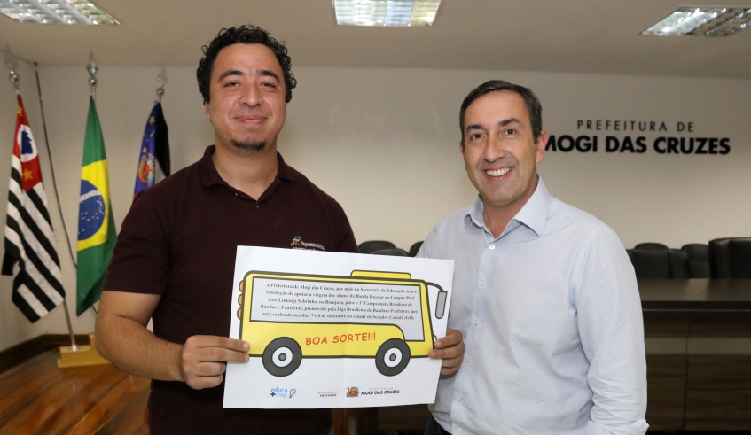 Prefeito Marcus Melo entregando o voucher que credencia a viagem ao coordenador da banda e maestro Eweton Ravelli. (Foto: Ney Sarmento/PMMC)